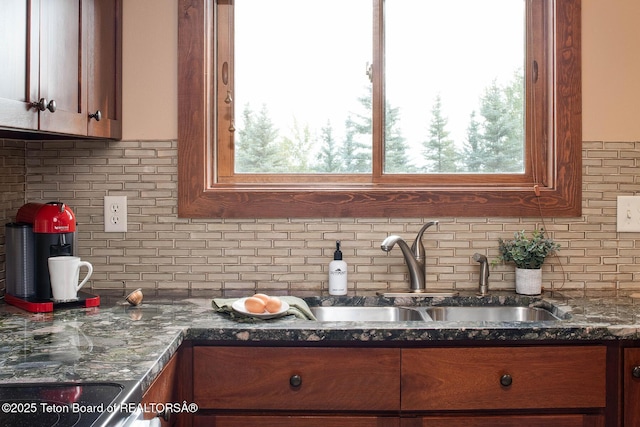 3670 W Michael Dr Unit E-21-E, Teton Village, WY 83025 - kitchen featuring a sink, tasteful backsplash, dark stone counters, and brown cabinets