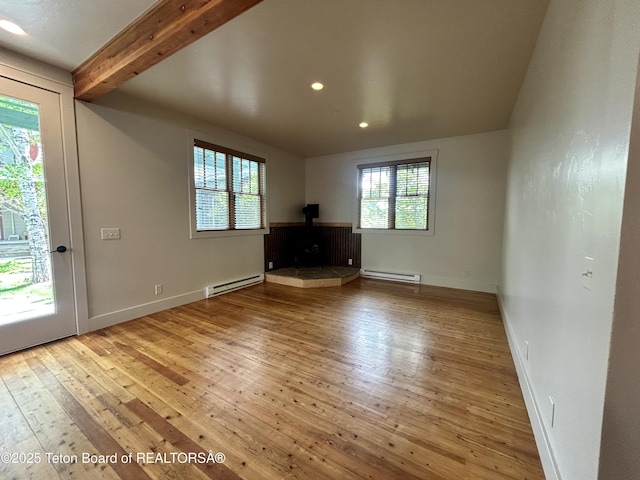9064 Village Way, Victor, ID 83455 - unfurnished living room with a wood stove, baseboard heating, hardwood / wood-style flooring, recessed lighting, and beam ceiling