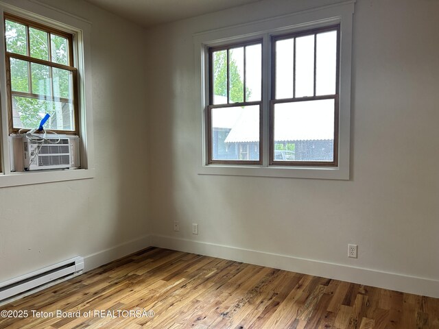 9064 Village Way, Victor, ID 83455 - empty room with a baseboard heating unit, baseboards, healthy amount of natural light, and wood finished floors