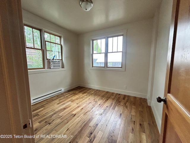 9064 Village Way, Victor, ID 83455 - unfurnished room with a baseboard heating unit, hardwood / wood-style floors, baseboards, and cooling unit