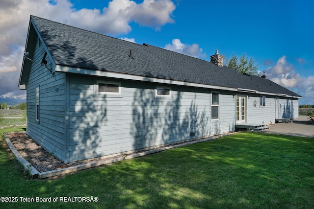 2697 Rendezvous Dr, Driggs, ID 83422 - back of property with a patio, a chimney, a lawn, and a shingled roof