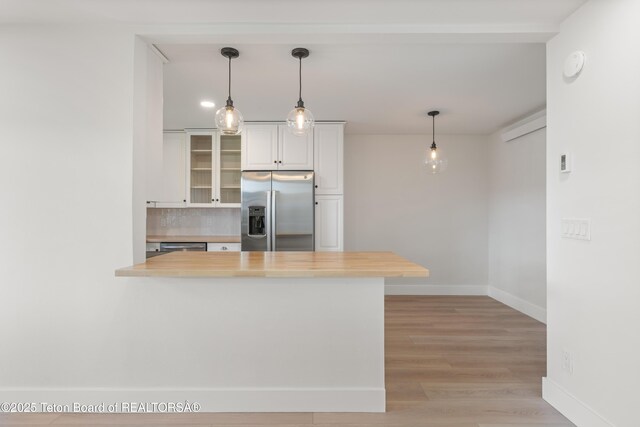 826 Powderhorn Ln Unit C, Jackson, WY 83001 - kitchen with stainless steel fridge, baseboards, a peninsula, glass insert cabinets, and light wood-type flooring