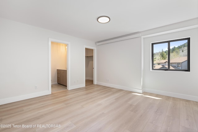 826 Powderhorn Ln Unit C, Jackson, WY 83001 - unfurnished bedroom featuring light wood-type flooring, baseboards, a walk in closet, and a closet