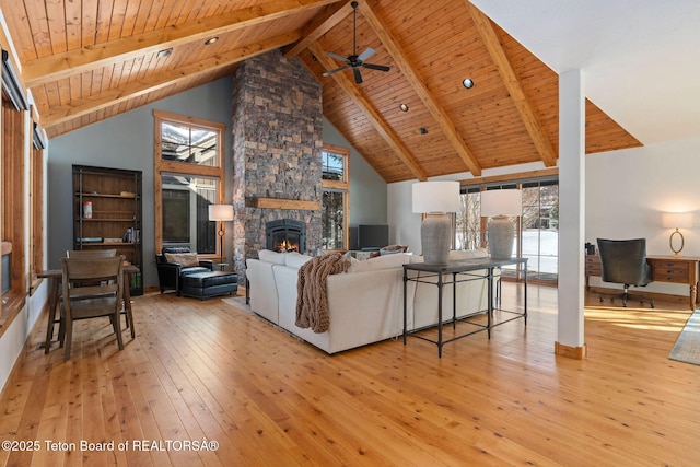 19 Moulton Ln, Victor, ID 83422 - living area featuring wood ceiling with exposed beams, light wood-style flooring, a ceiling fan, healthy amount of natural light, and a stone fireplace