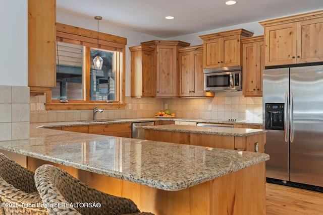 19 Moulton Ln, Victor, ID 83422 - kitchen with appliances with stainless steel finishes, a sink, light stone countertops, light wood finished floors, and recessed lighting