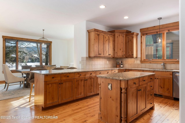 19 Moulton Ln, Victor, ID 83422 - kitchen with a sink, light wood-type flooring, decorative backsplash, stainless steel dishwasher, and a center island