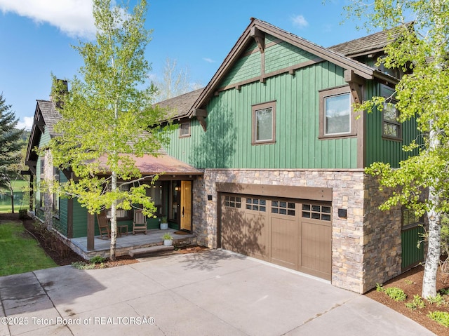 19 Moulton Ln, Victor, ID 83422 - chalet / cabin with stone siding, board and batten siding, concrete driveway, a garage, and a porch