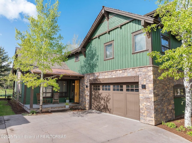 19 Moulton Ln, Victor, ID 83422 - view of front of property featuring stone siding, board and batten siding, covered porch, a garage, and driveway