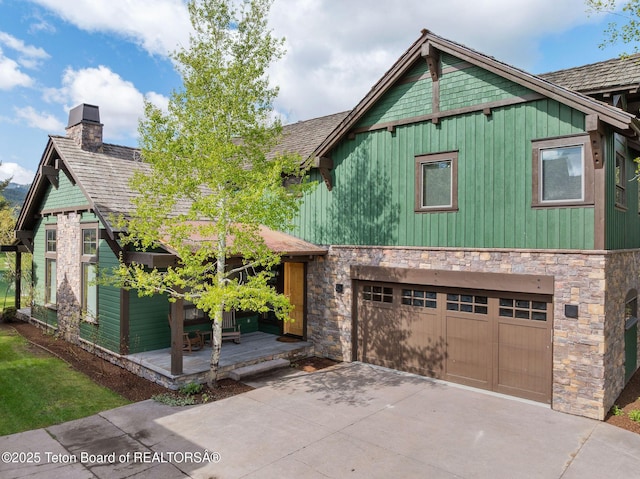 19 Moulton Ln, Victor, ID 83422 - view of front facade with a chimney, stone siding, a garage, and driveway