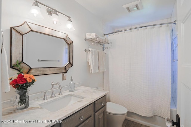 full bathroom with toilet, vanity, wood finished floors, and shower / bath combo
