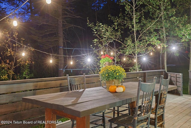 deck at night with outdoor dining space