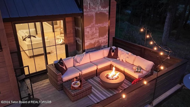 wooden deck featuring an outdoor living space with a fire pit