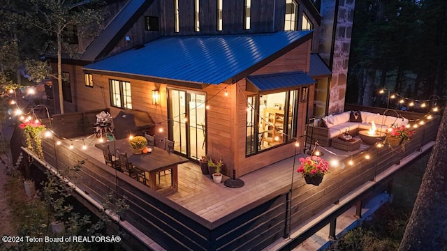 back of house with an outdoor fire pit, a deck, french doors, and a jacuzzi