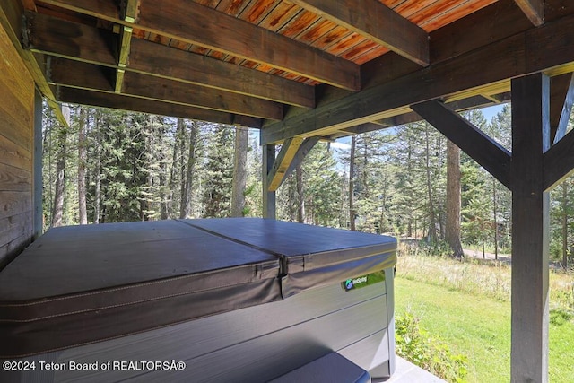 deck with a hot tub and a yard