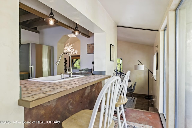 2077 Highland Way, Victor, ID 83455 - kitchen with freestanding refrigerator, tile countertops, a chandelier, and beamed ceiling