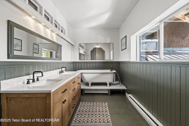 2077 Highland Way, Victor, ID 83455 - bathroom featuring wainscoting, a freestanding tub, baseboard heating, and double vanity