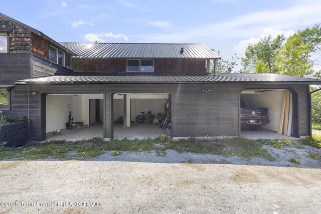 2077 Highland Way, Victor, ID 83455 - back of property with a garage, a metal roof, and dirt driveway