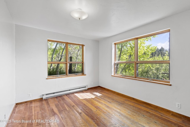 2077 Highland Way, Victor, ID 83455 - spare room with baseboard heating, plenty of natural light, and wood-type flooring