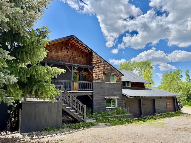 2077 Highland Way, Victor, ID 83455 - rustic home featuring driveway, stairs, and a metal roof