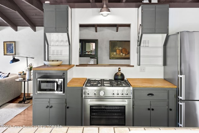 2077 Highland Way, Victor, ID 83455 - kitchen featuring appliances with stainless steel finishes, gray cabinets, butcher block counters, light wood finished floors, and beamed ceiling