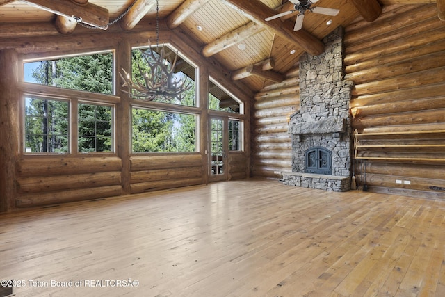5725 W Caddis Fly Dr, Wilson, WY 83014 - unfurnished living room with rustic walls, a wood ceiling with exposed beams, high vaulted ceiling, a stone fireplace, and ceiling fan