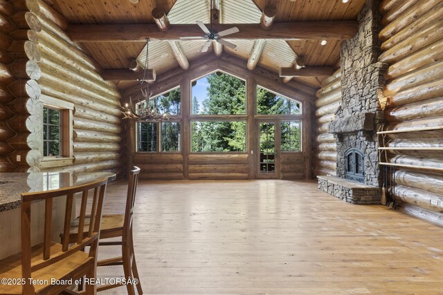 5725 W Caddis Fly Dr, Wilson, WY 83014 - unfurnished living room featuring a wood ceiling with exposed beams, rustic walls, hardwood / wood-style flooring, ceiling fan, and high vaulted ceiling