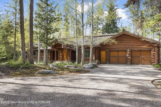 5725 W Caddis Fly Dr, Wilson, WY 83014 - log cabin with log siding, driveway, and a garage