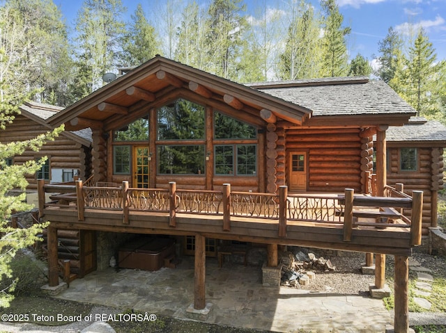 5725 W Caddis Fly Dr, Wilson, WY 83014 - back of house with log exterior, a deck, and a patio area