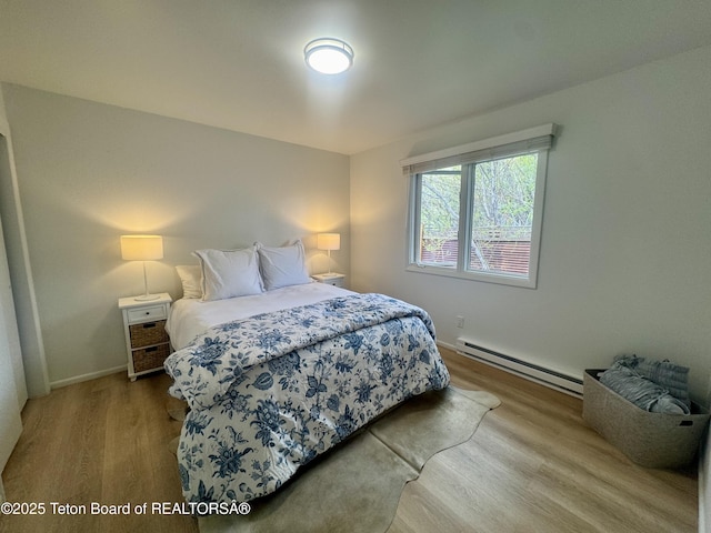 385 N Glenwood St, Jackson, WY 83001 - bedroom featuring a baseboard radiator, wood finished floors, and baseboards