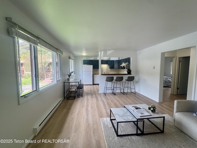 385 N Glenwood St, Jackson, WY 83001 - living room with baseboard heating, light wood-style flooring, and baseboards