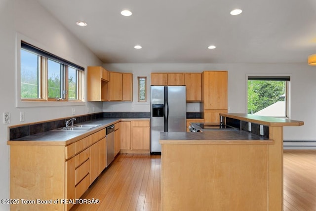 668 S Millward St, Jackson, WY 83001 - kitchen with appliances with stainless steel finishes, a sink, light wood-style flooring, a center island, and dark countertops