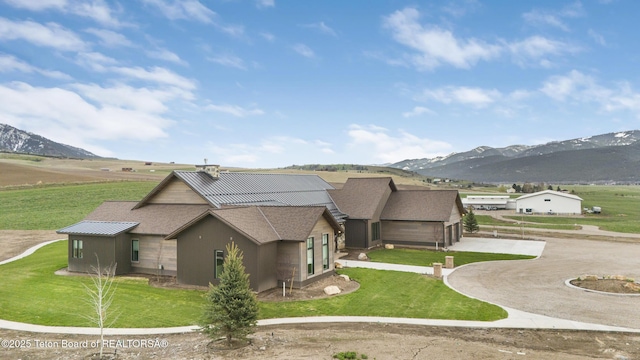 2399 Chapel Rd, Swan Valley, ID 83449 - view of home's exterior featuring curved driveway, a mountain view, a lawn, and roof with shingles