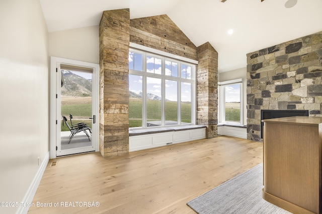 2399 Chapel Rd, Swan Valley, ID 83449 - unfurnished dining area with high vaulted ceiling, wood finished floors, and a fireplace