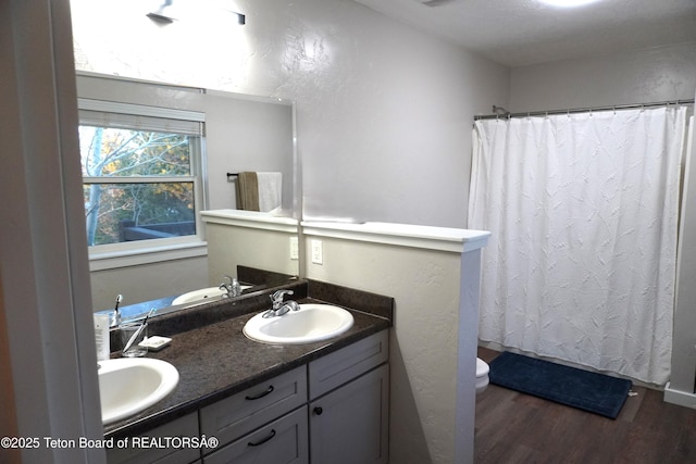 418 Par Ave, Pinedale, WY 82941 - full bathroom featuring wood finished floors, toilet, double vanity, and a shower with curtain