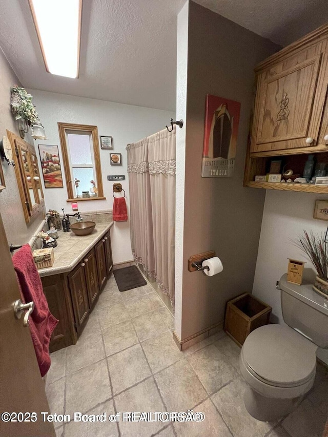 216 County Road 179s, Thayne, WY 83127 - full bath with toilet, a shower with shower curtain, a textured ceiling, and vanity