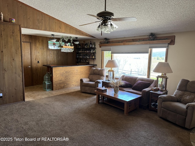 216 County Road 179s, Thayne, WY 83127 - carpeted living area featuring wooden walls, a textured ceiling, ceiling fan, a dry bar, and lofted ceiling