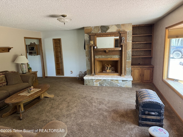 216 County Road 179s, Thayne, WY 83127 - carpeted living area with built in shelves, a textured ceiling, and a stone fireplace