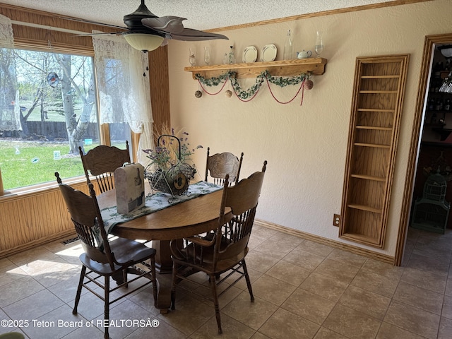 216 County Road 179s, Thayne, WY 83127 - tiled dining space featuring a textured ceiling, a textured wall, a ceiling fan, baseboards, and crown molding