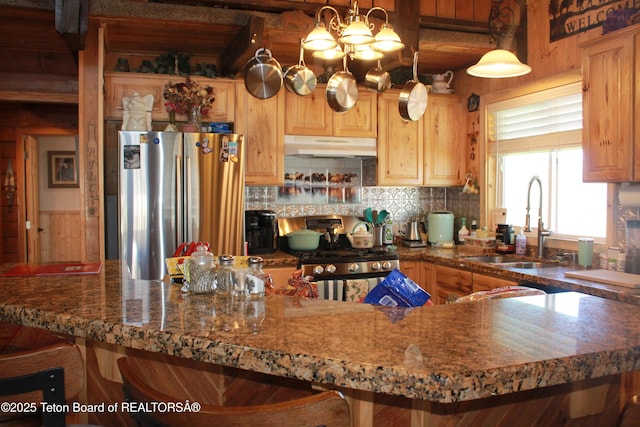 588 S Oak St, Labarge, WY 83123 - kitchen with appliances with stainless steel finishes, a sink, under cabinet range hood, beamed ceiling, and decorative backsplash