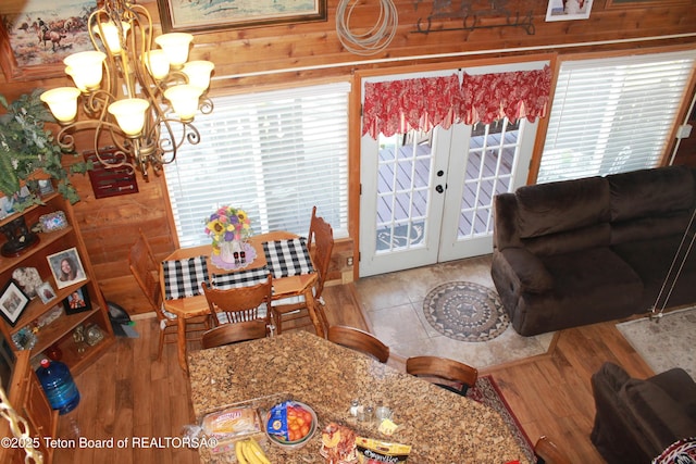 588 S Oak St, Labarge, WY 83123 - dining area with a chandelier, plenty of natural light, french doors, wood finished floors, and wood walls