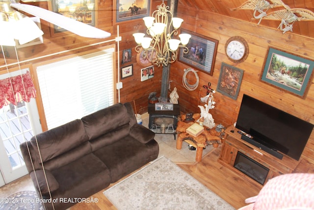 588 S Oak St, Labarge, WY 83123 - living area featuring a chandelier, wooden walls, a wood stove, healthy amount of natural light, and wood finished floors