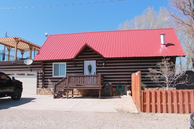 588 S Oak St, Labarge, WY 83123 - view of front of house featuring metal roof, an attached garage, and log siding