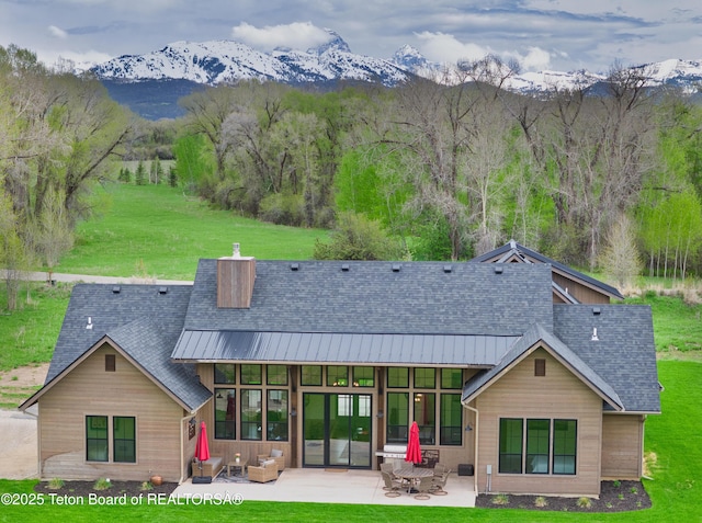 358 Solitude Ln, Tetonia, ID 83452 - rear view of house with a mountain view, a patio, a lawn, a standing seam roof, and roof with shingles