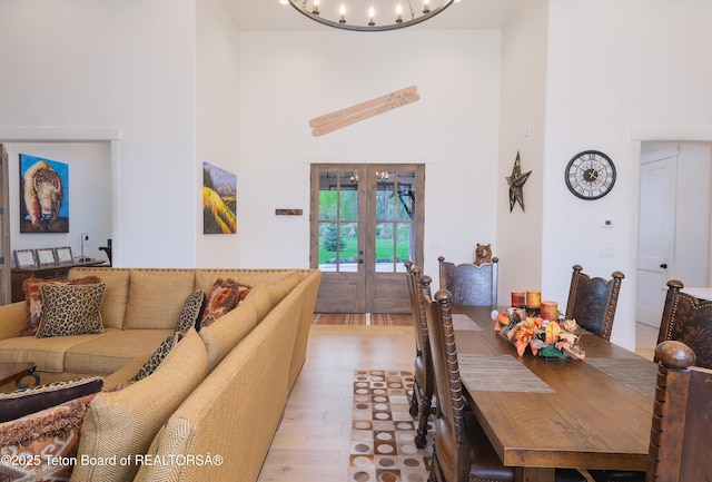 358 Solitude Ln, Tetonia, ID 83452 - dining room with a towering ceiling, french doors, light wood-style floors, and a chandelier