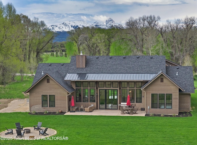 358 Solitude Ln, Tetonia, ID 83452 - rear view of house featuring a patio, a fire pit, a mountain view, a yard, and a standing seam roof