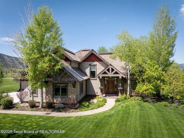 62 Hastings Dr, Victor, ID 83455 - craftsman-style house with stone siding, a front yard, and roof mounted solar panels