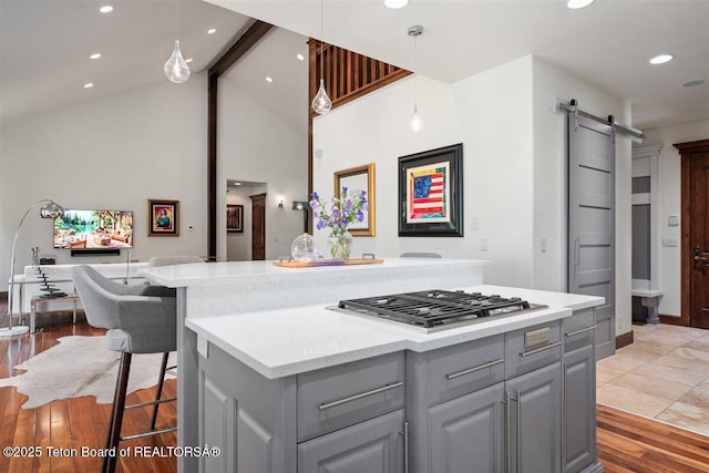 62 Hastings Dr, Victor, ID 83455 - kitchen with gray cabinets, stainless steel gas stovetop, a barn door, light countertops, and open floor plan