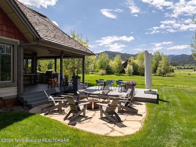 62 Hastings Dr, Victor, ID 83455 - view of patio / terrace with a fire pit and a deck with mountain view