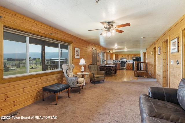 188 E 3000 S, Driggs, ID 83422 - living room featuring wooden walls, ceiling fan, light carpet, and a textured ceiling