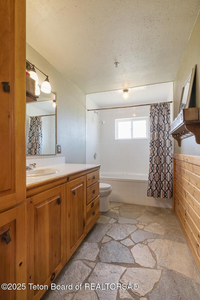 188 E 3000 S, Driggs, ID 83422 - full bath featuring a textured ceiling, vanity, toilet, tiled shower / bath, and stone finish flooring
